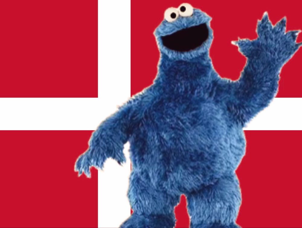 Cookie Monster standing Patton-style in front of a giant Danish flag