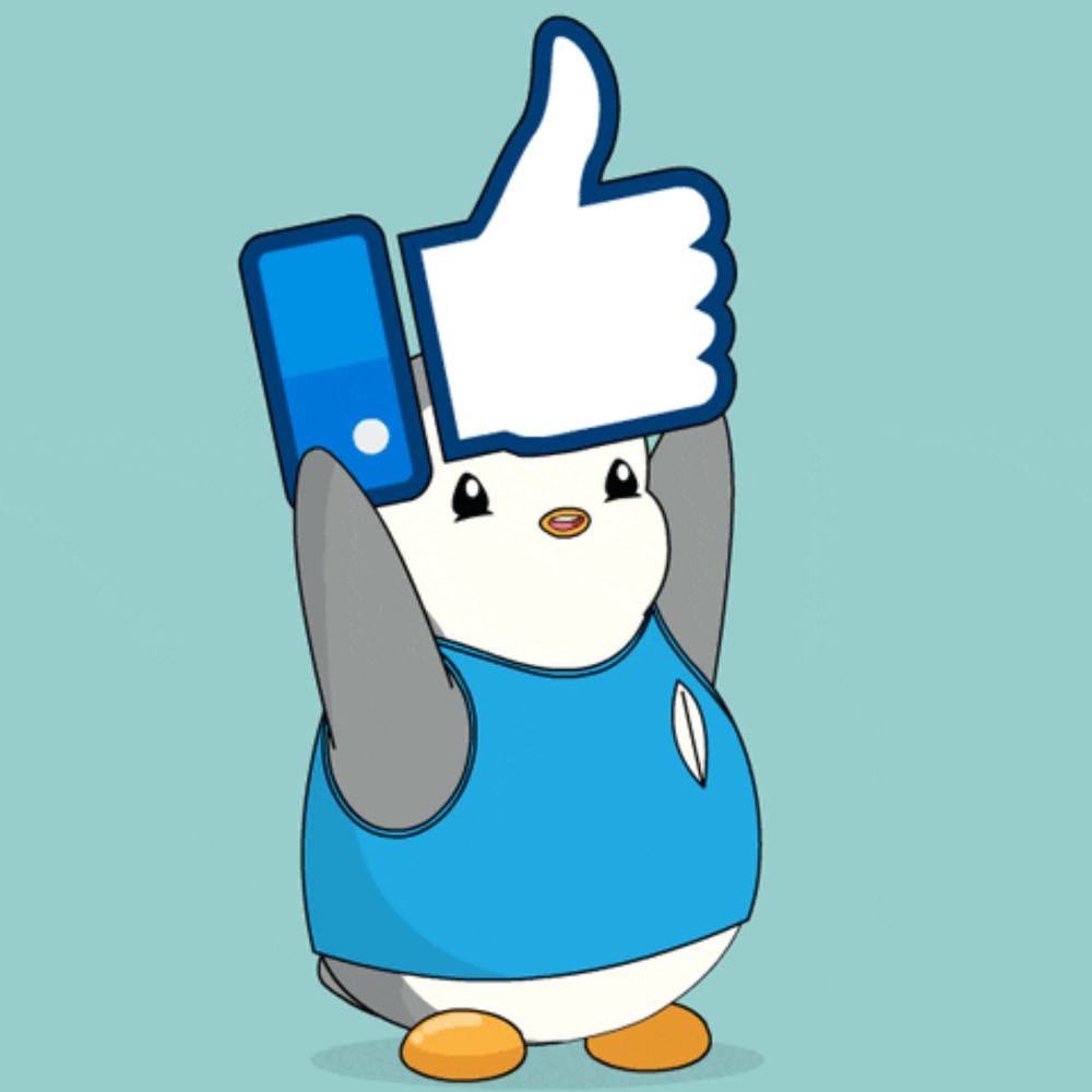 a penguin wearing a blue shirt is holding a thumbs up sign over its head