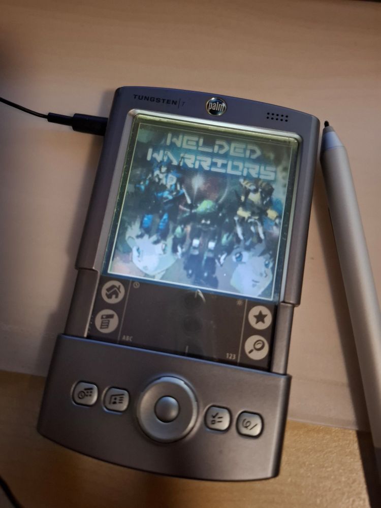 A Palm PDA showing the title screen of the game Welded Warriors