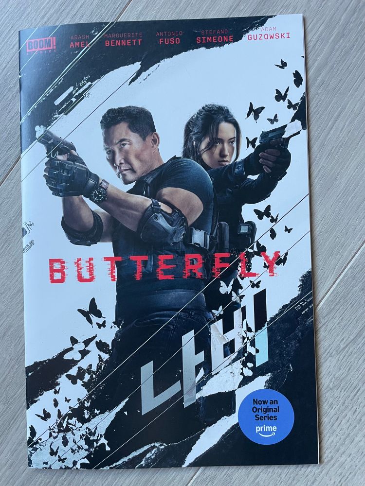 Butterfly comic book with Daniel Dae Kim and Reina Hardesty holding guns, surrounded by butterflies