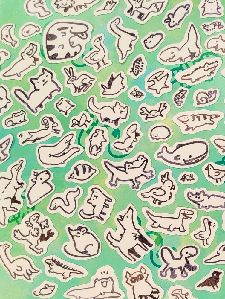 An assortment of sharpie doodle animal stickers on a greenish background 