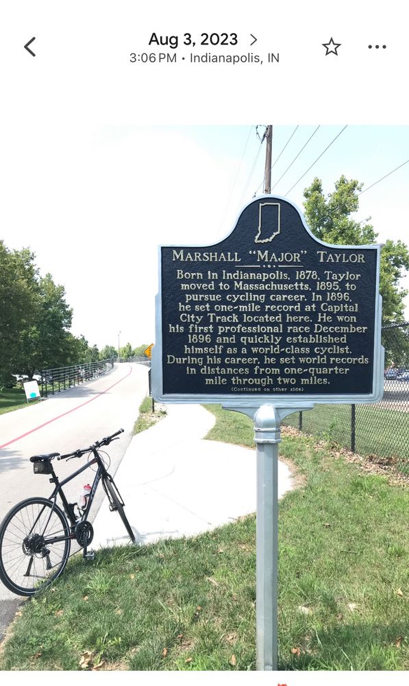 Major Taylor historical marker on Monon Trail near Indiana State Fair Grounds. A black bike in background.  August 2023. 