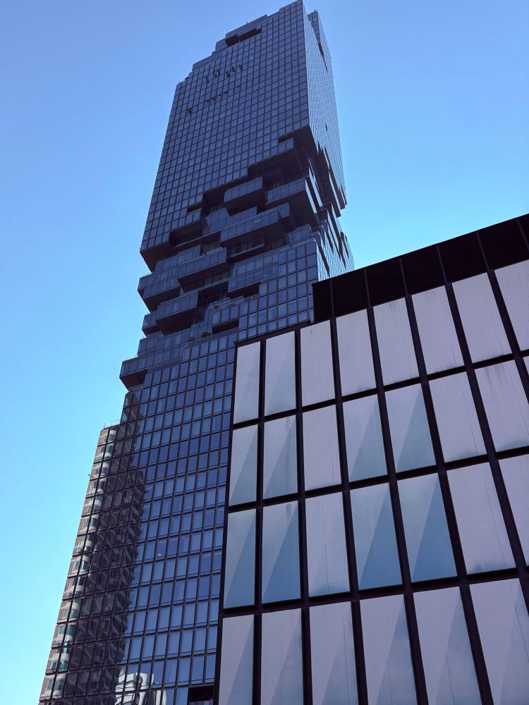 Großes Hochhaus mit kubistischen Elementen vor blauem Himmel 