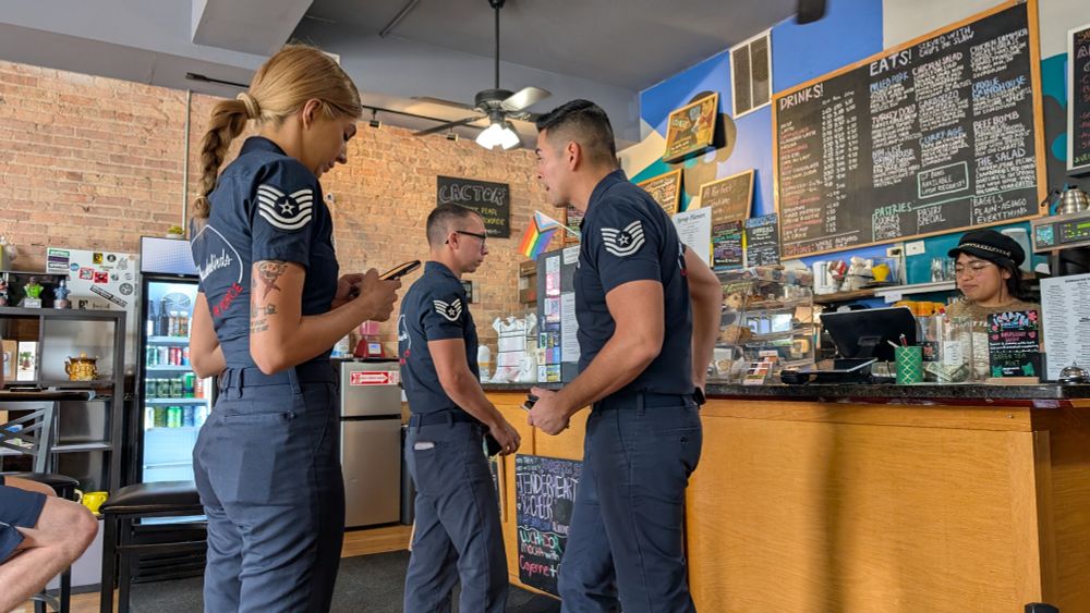 Some airmen in a cafe. Their uniforms indicate that they are with the Thunderbirds. 