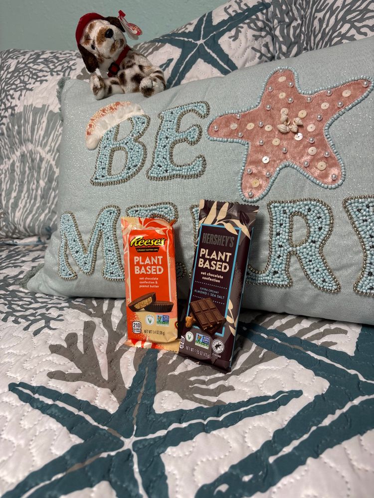 Vegan Reese’s cups and Hershey’s chocolate bar resting on a pillow. 