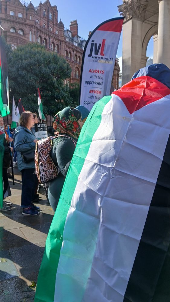 Protesters with flags and banners, including the Jewish community