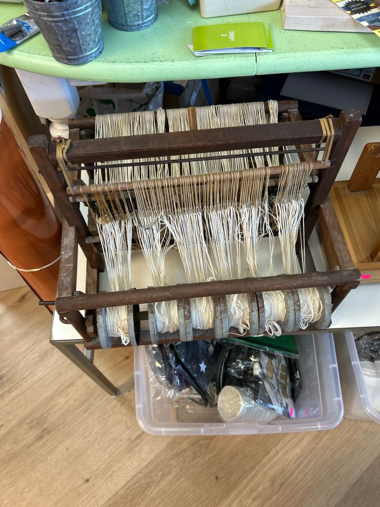 A vintage table loom in a craft store. The heddles are petrified rubber bands. 
Some repair will soon be required!