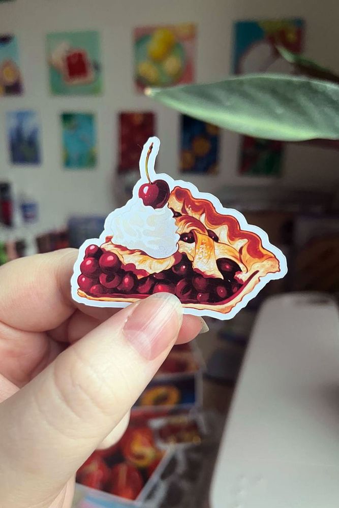 me holding a cherry pie sticker with whipped cream and a cherry on top