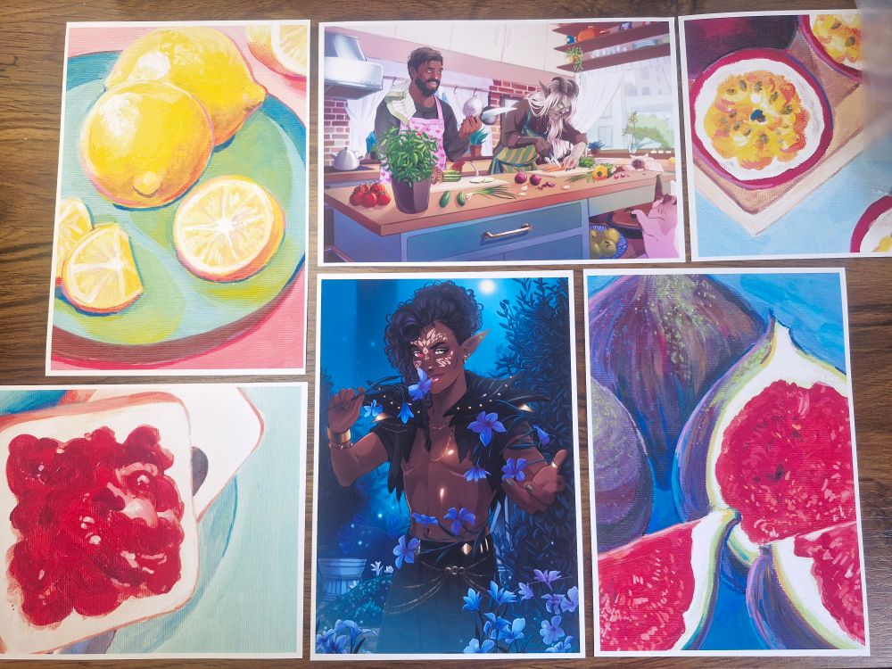 A few prints of various fruits that I painted, layed out on a crafting table.