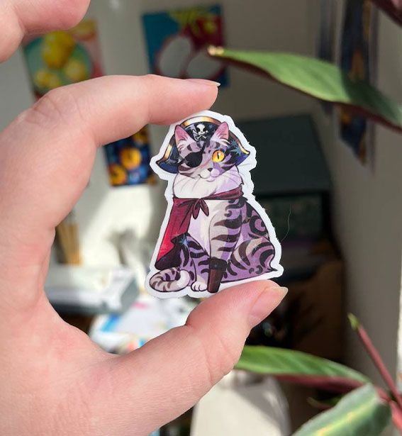 Savage Purrate. Sticker of a spooky kitty. A gray tabby in pirate attire.