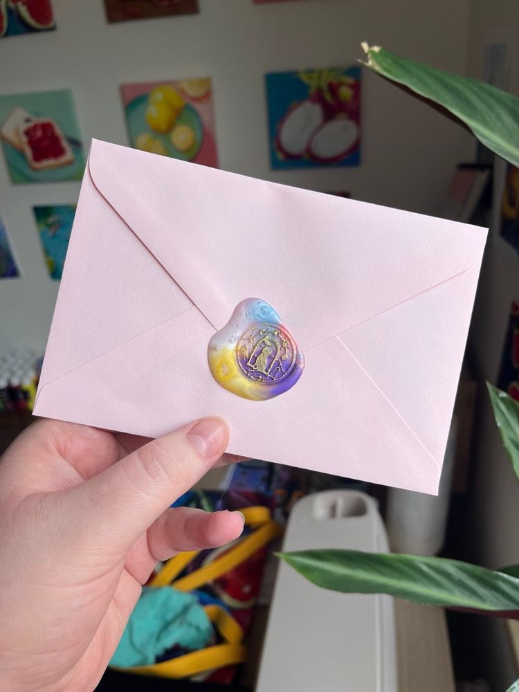 me holding a pink C6 envelope with a whimsical wax seal