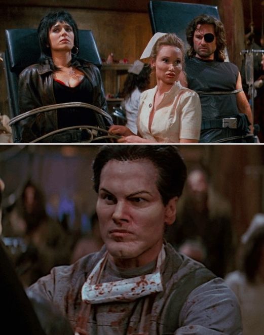 Still image of Escape from LA showing a Black haired woman and a man wearing a Black patch on his left eye atached to vertical beds by a nurse and a surgeon with face implants.