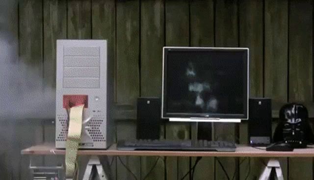 a computer is on a desk next to a darth vader mask