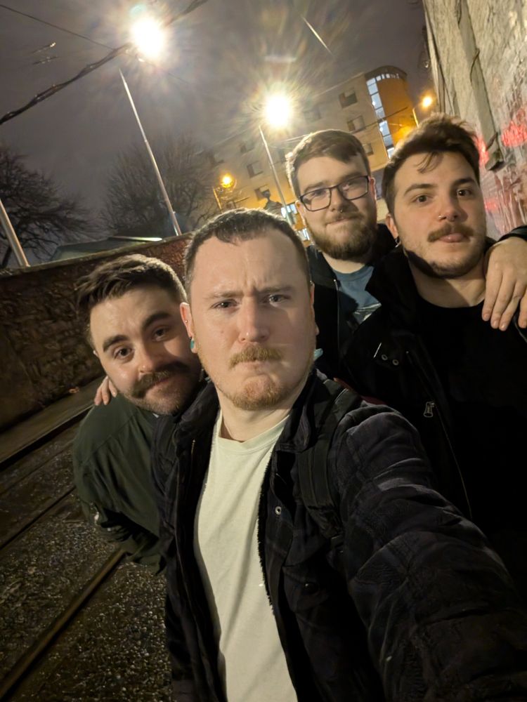 4 white men outside late at night 