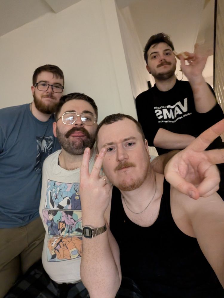 4 white men in a kitchen, looking slightly drunk