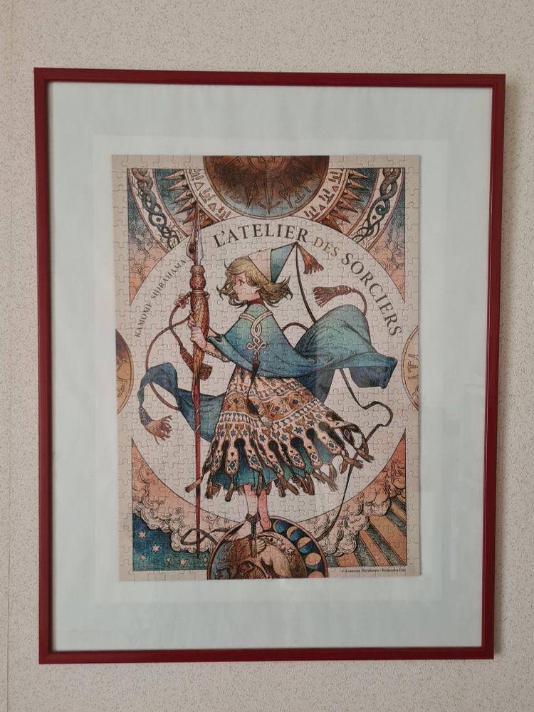 Un puzzle représentant une illustration de l'héroïne de "L'Atelier des Sorciers" est encadré et suspendu au mur. Il était vendu avec le tome 12 de la série en version collector.
