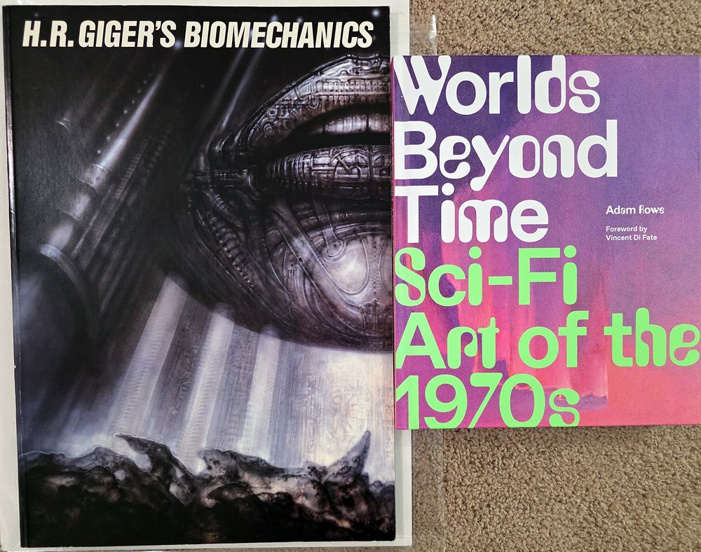 Photo of two books - one is "H.R.Giger's Biomechanics," and the other is "Worlds Beyond Time: Sci-Fi Art of the 1970s" by Adam Rowe