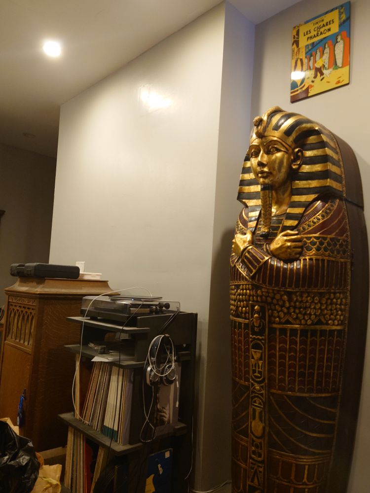 An Egyptian sarcophagus standing next to a record player.
