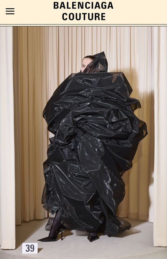Balenciaga couture model wearing what looks like a pile of satin trash bags and stylish heels 