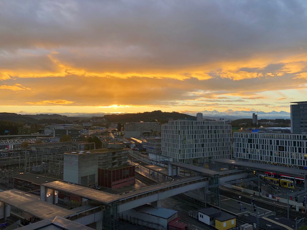 Aussicht auf den Bahnhof Wankdorf mit Sonnenaufgang im Hintergrund.
