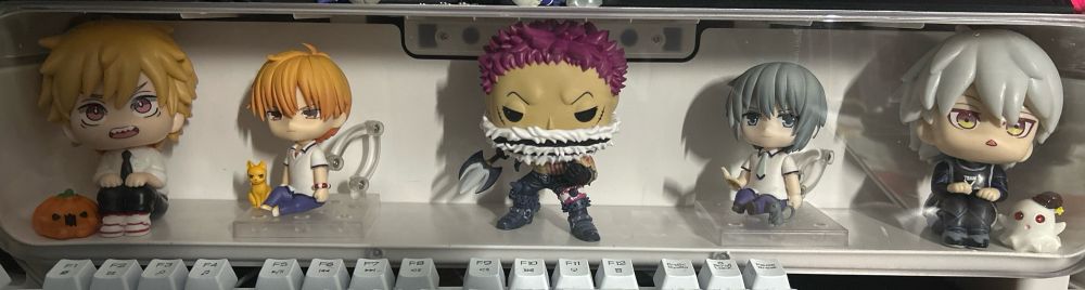 White display box with various anime figures 
From left to right: Denji from chainsaw man, Kyo from fruits basket, Katakuri from one piece, Yuki from fruits basket, Nagi from Blue lock 