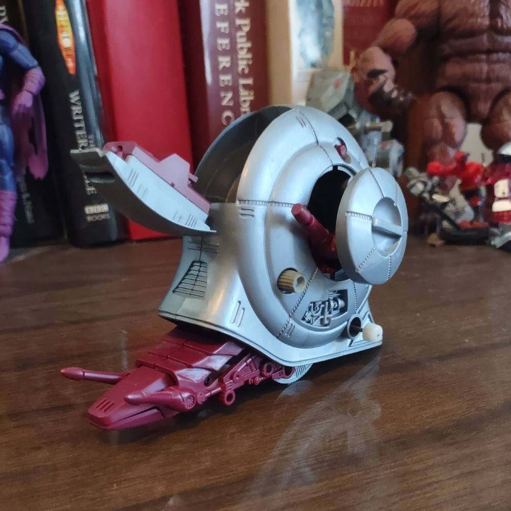 The same toy robot snail. Now its head and neck (???) are stretched out and parts of its shell have opened up to reveal more guns.