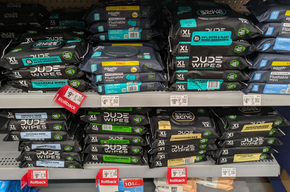 Two Walmart shelves full of 'Dude Wipes' brand flushable wet wipes.