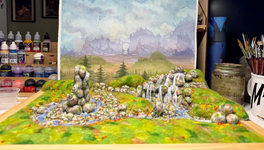 A 3D needle felted landscape with a standing stone, river and waterfall