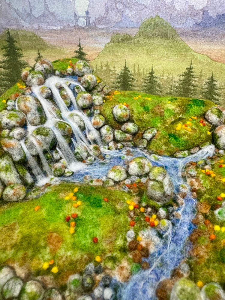 A 3D needle felted landscape with a standing stone, river and waterfall
