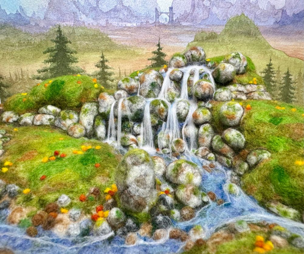 A 3D needle felted landscape with a standing stone, river and waterfall
