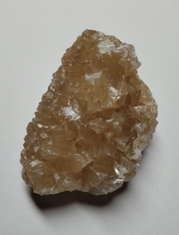 A small crystal cluster with a soft yellowish brown color.