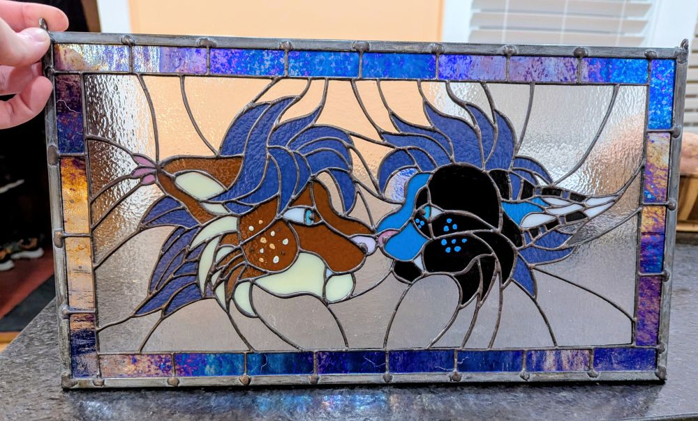 Stained glass art depicting Strobes and Gale headshots touching by the nose 