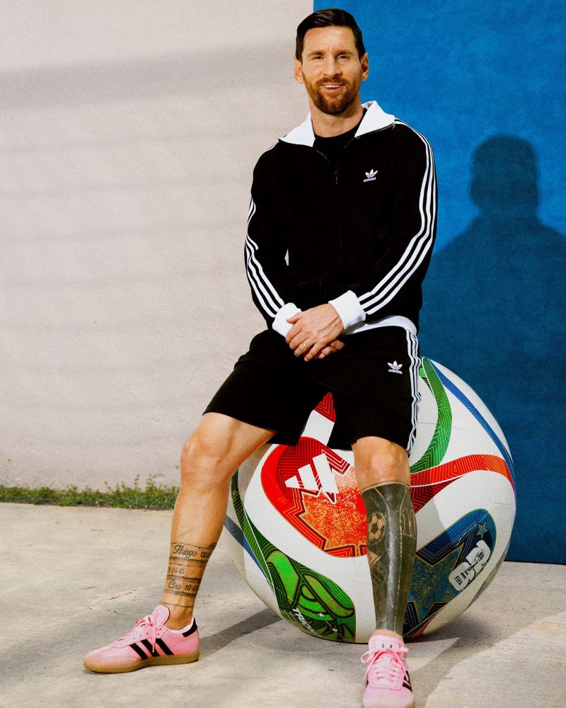 The best football player of all time sitting on the huge new World Cup football. It’s Lionel Messi.