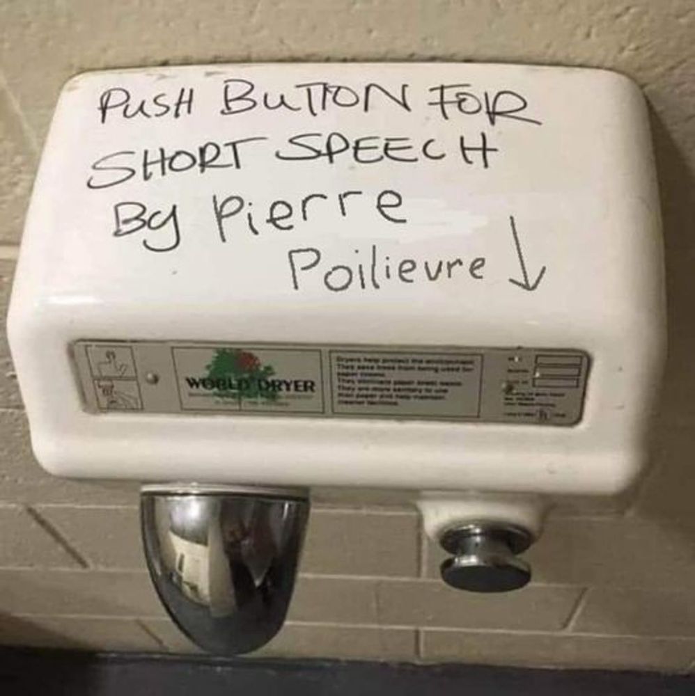 Photo of a washroom hand dryer features a hand-written message: "Push button for short speech by Pierre Poilievre". An arrow points to the botton. 