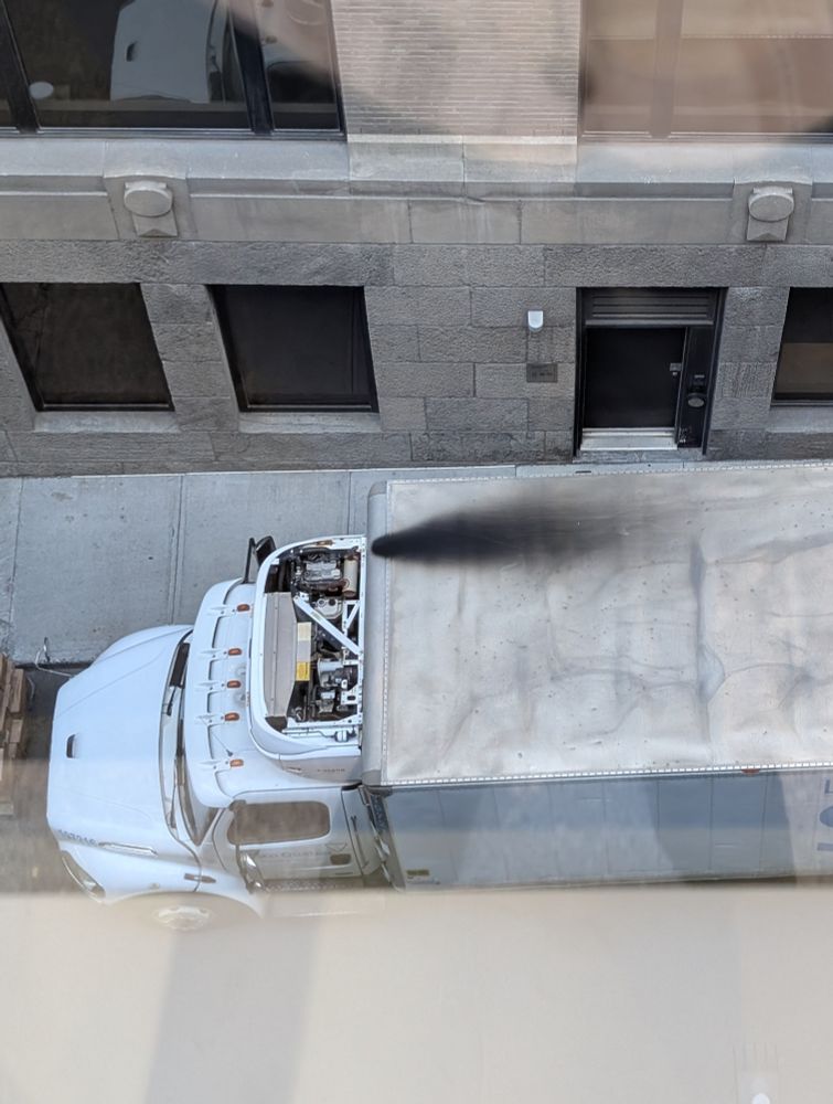 View from above of black stain of exhaust emissions on the roof of a semitruck. 