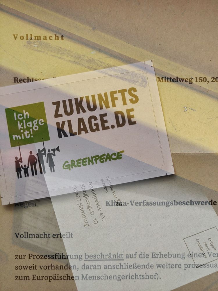 Sticker "Zukunftsklage.de - ich klage mit! / Greenpeace"  zusammen mit Schreiben für anwaltliche Vollmacht sowie absendefertigem Briefumschlag im Briefkastenschlitz (Fotomontage)