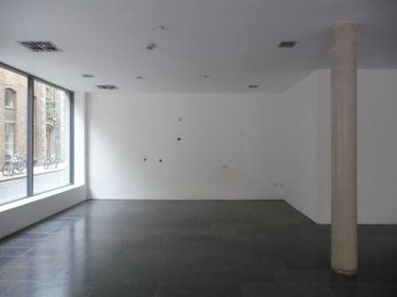 Photo from 2009 of the empty shop unit showing white walls, a pillar and slate floor.