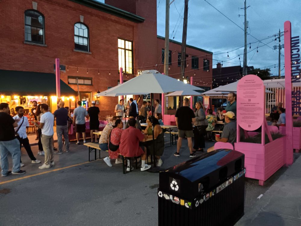 Dozens of people sitting at tables and standing around at the uncommon space off Bank Street