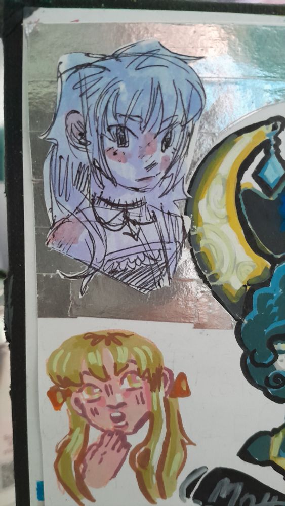 a doodle that I did on a scrap piece of paper that I cut out and then stuck in over metallic washi tape. It's of a girl with long, messy hair that has bangs. She's wearing a basic black tank top with two necklaces. I coloured her in with a light blue highlighter with some pink for the blush.  The drawing right below was made using acrylic markers. It's a quick drawing of a girl, but it's just to practice an expression, so I only drew her face and one of her hands. She's pale with golden eyes and hair, she has large eyes and chubby cheeks and she has a shocked expression on her face, her hand is pressed against her chin. Her hair is styled into two low pigtails with two orange bows and she has bangs.