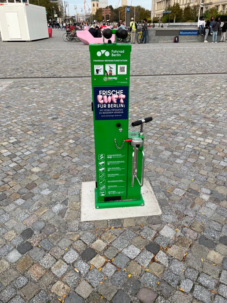 grüner Luft-/Ersatzteilautonat auf Pflastersteinen