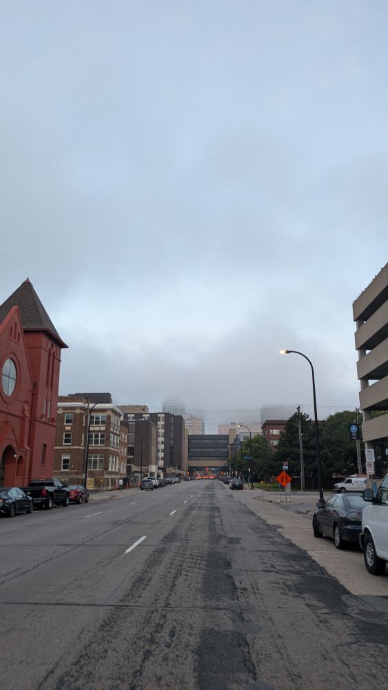 Grey foggy skies above a street with buildings next to and over it in Downtown Minneapolis 