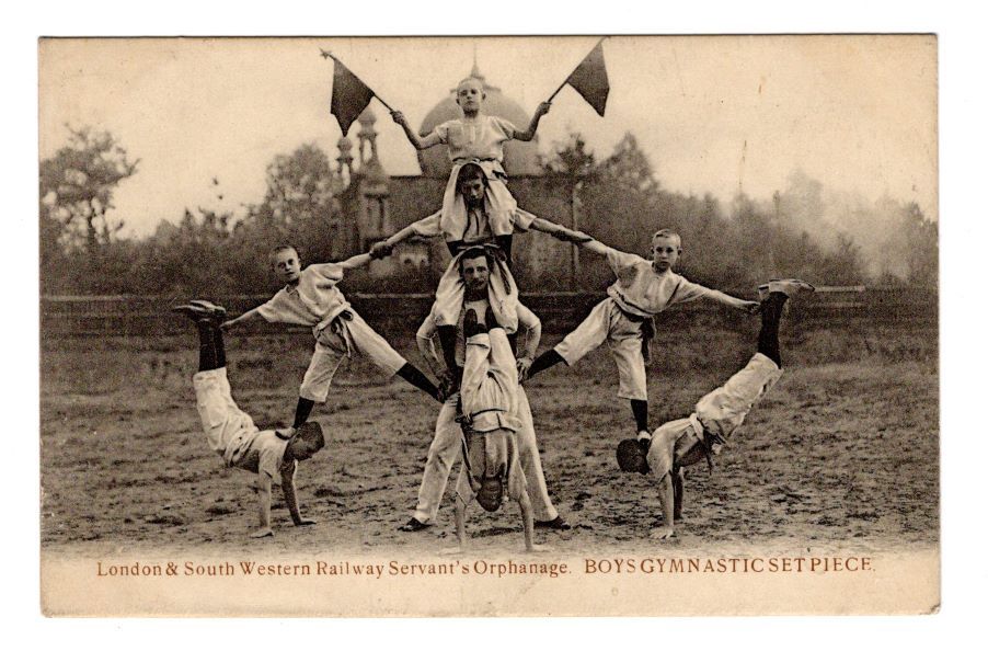 Postcard showing boys from the London and South Western Railway Servants’ Orphanage undertaking a gymnastic display outside, possibly in front of Woking mosque.
