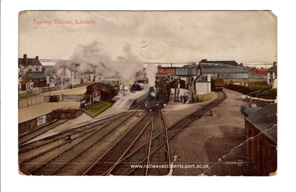 Colourised early 20th-century postcard, showing a steam engine leaving Llanelli station. 