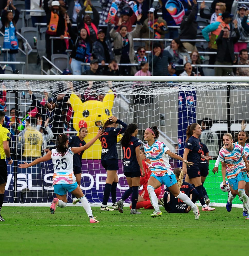 Trinity Armstrong celebrates after scoring the game winning goal. In the background, someone dressed like Pikachu is in the crowd.