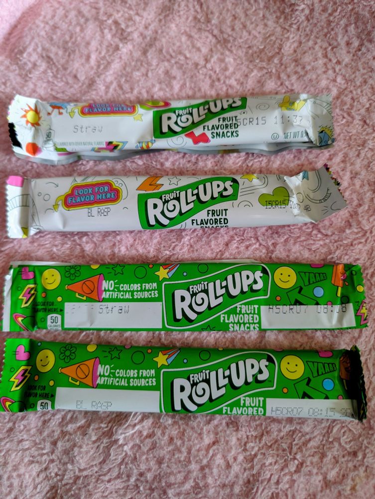 Two sets of blue and red fruit roll ups, one from the original recipe and the green package one is new, containing no artificial colors