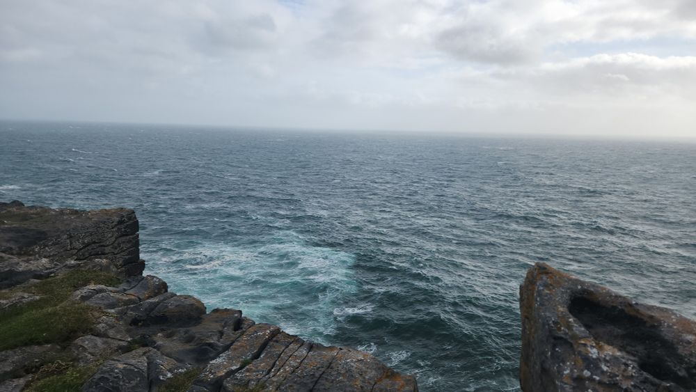Picture looking over a cliff and a wide expanse of ocean