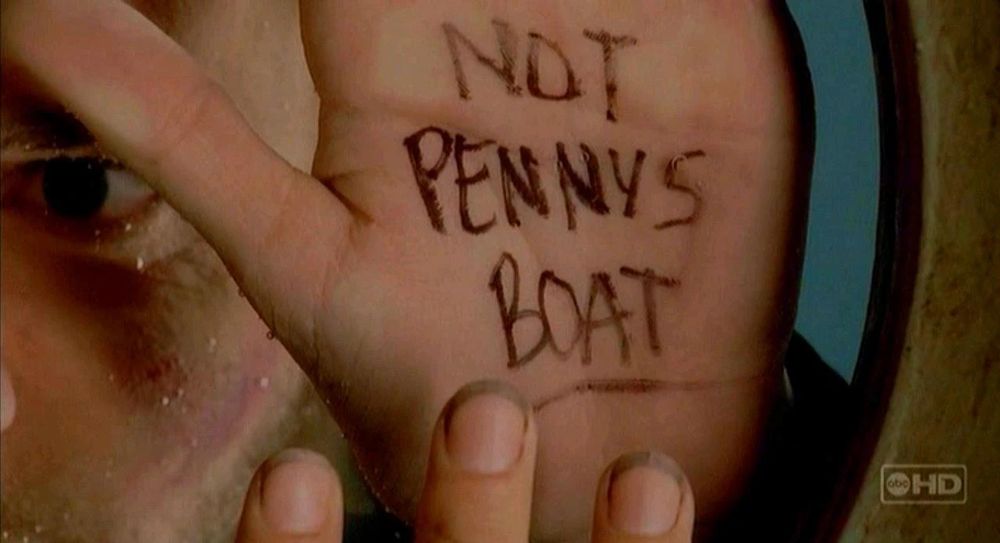 Charlie’s hand against a porthole with the words “Not Penny’s Boat” written on them.