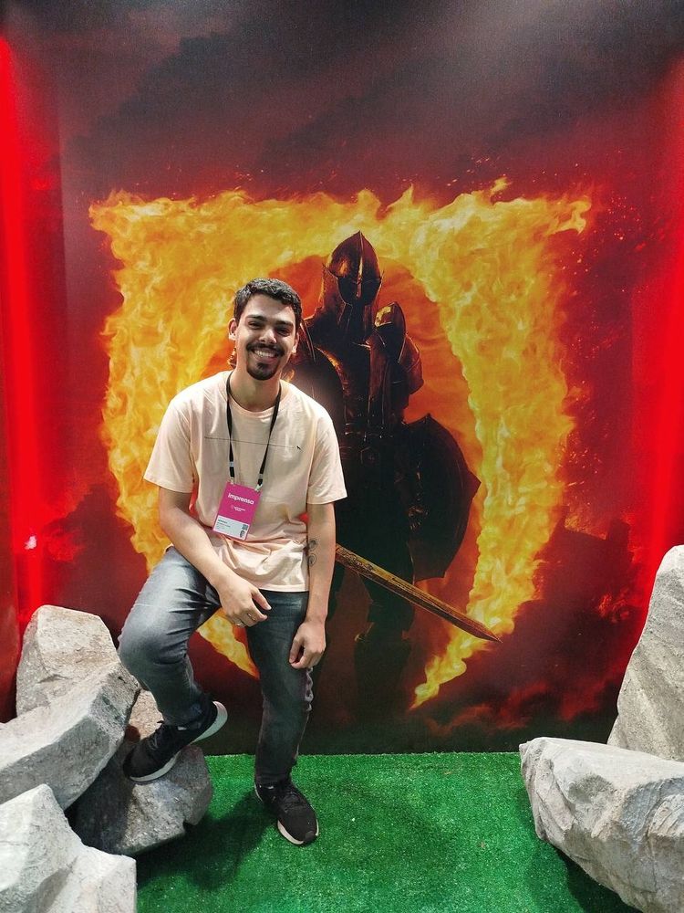 Victor, um dos nossos representantes na gamescom latam, posando em frente a um banner de The Elder Scrolls Oblivion Remastered