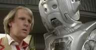 Peter Davison and a Cyberman look conspiratorial.
