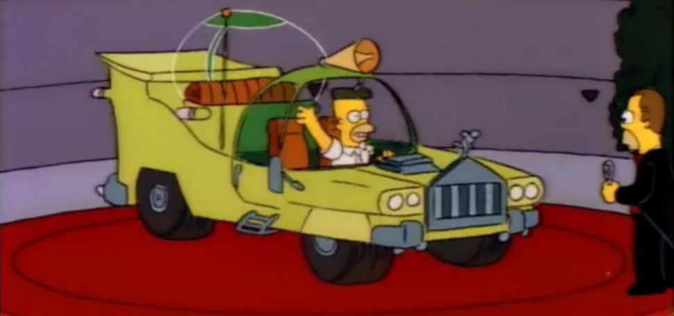Home Simpson waving hello, from behind the wheel of the horrible car that he helped design.